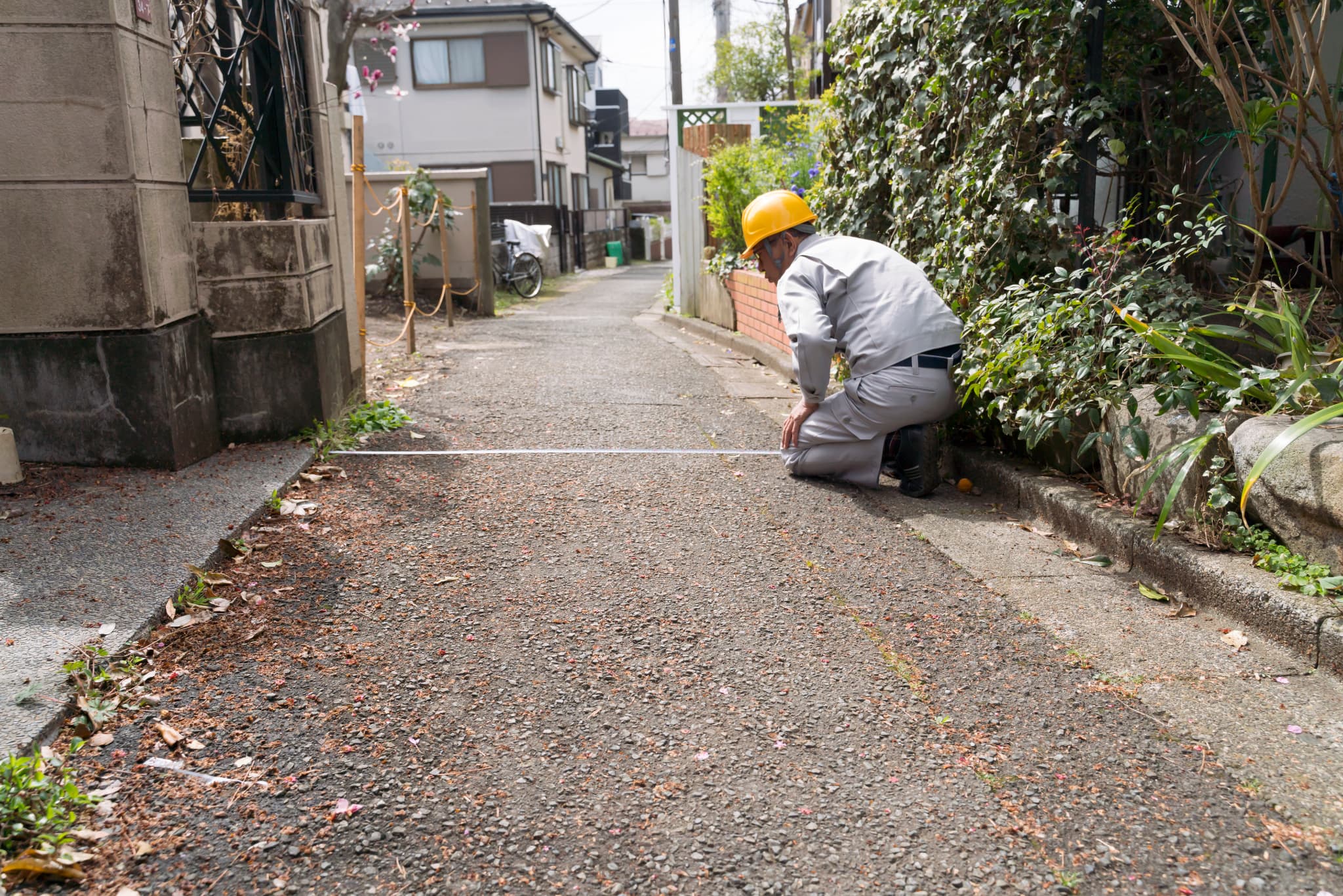 現地調査　建て替えで接道を採寸する風景